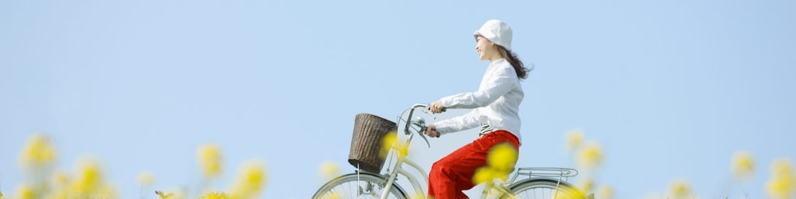 Une jeune femme fait une promenade à vélo dans un champ en été